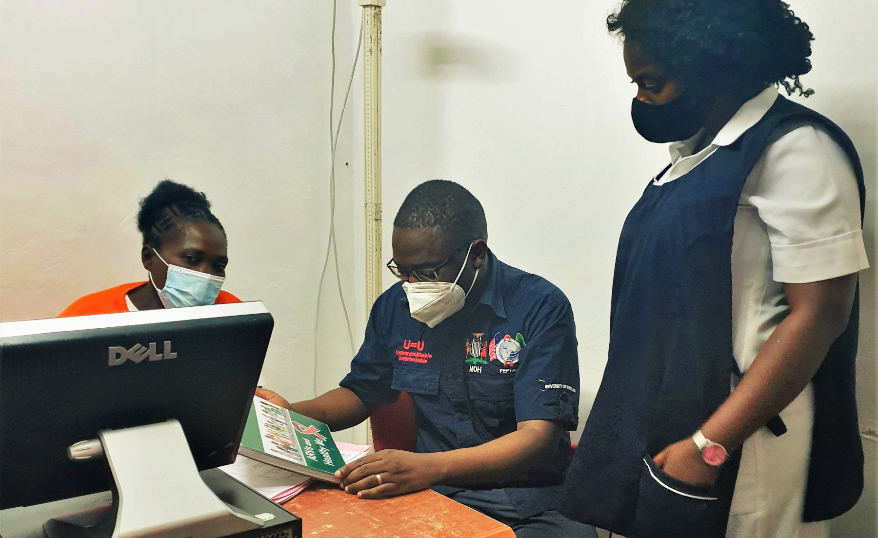Dr Sivile and HIV testers at the clinic review the log-books and discuss the data together.